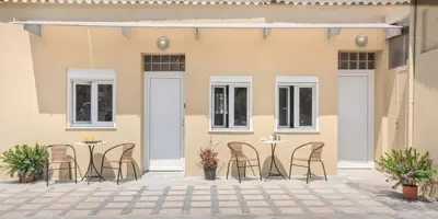 a patio with chairs and tables in front of a building at Rea Studio 3 in Chania Town
