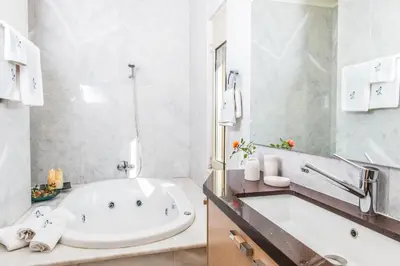 a white bathroom with a tub and a sink at Villa Mariposa - panoramic sea view - near Chania city in Chania Town