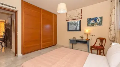 a bedroom with a bed and a desk with a chair at Lithos Serenity in Argoulidhés