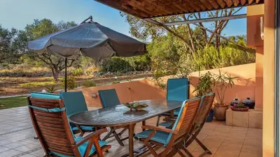 a table and chairs with an umbrella on a patio at Lithos Serenity in Argoulidhés
