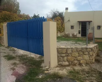 a blue fence next to a stone wall at Casa Antica