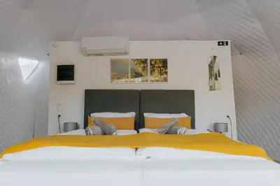 a bedroom with a large white bed with yellow sheets at Lemon Dome, Luxury Glamping Dome in Crete in Gavalochori