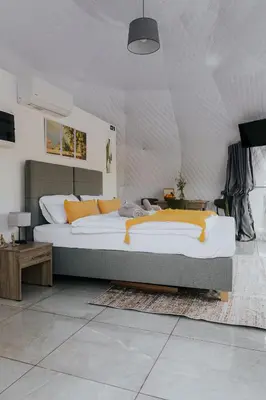 a bedroom with a large bed with orange pillows at Lemon Dome, Luxury Glamping Dome in Crete in Gavalochori