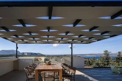 a dining room with a table and chairs on a balcony at Villa Maninee-Bespoke Villa-Pool -BBQ-Seaview in Chania Town