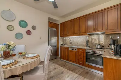 a kitchen with wooden cabinets and a table with chairs at Garden house by Dreams in Chania Town