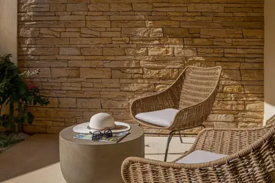 a hat sitting on a table next to two chairs at Ocean Bay Sea View Apartment, Pool, Brand New, 2B in Kalyves