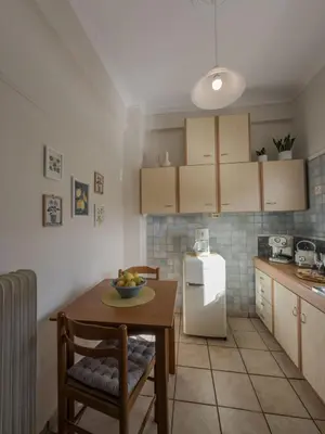 a kitchen with a table and a white refrigerator at Sunny Nest, Stylish & Bright Urban Retreat in Chania Town