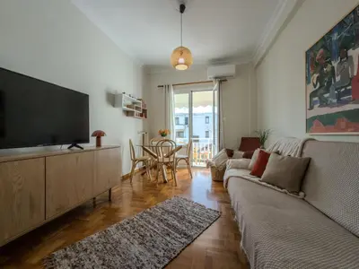 a living room with a couch and a flat screen tv at Sunny Nest, Stylish & Bright Urban Retreat in Chania Town