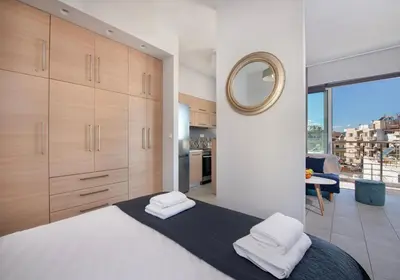 a bedroom with a large bed and a mirror at Stelios Florans Apartment in Chania Town
