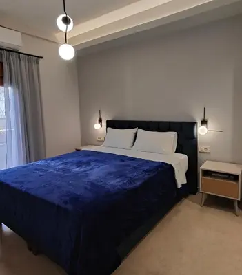a bedroom with a large bed with a blue blanket at Modern Central Apartment - 400m to Beach in Kissamos