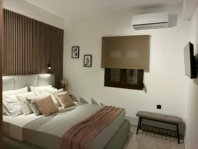 a bedroom with a large bed and a television at Karadinos Apartment in Stílos