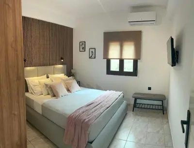 a bedroom with a large bed and a television at Karadinos Apartment in Stílos