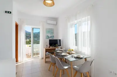 a dining room with a table and chairs and a television at Almyrida Bayview VII - BY APOKORONAS VILLAS in Almirida