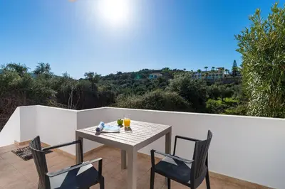 a table and two chairs on a patio with a view at Almyrida Bayview VII - BY APOKORONAS VILLAS in Almirida