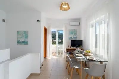 a dining room with white walls and a table and chairs at Almyrida Bayview VII - BY APOKORONAS VILLAS in Almirida