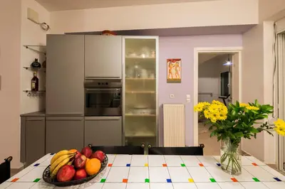 a kitchen with a table with a bowl of fruit at Villa Joy Mare - Seaside Escape with Private Pool in Aghii Apostoli