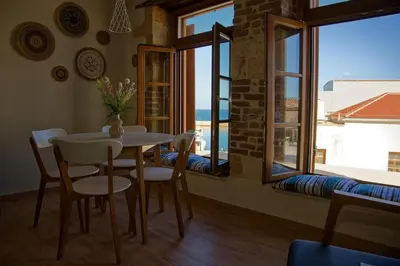 a dining room with a table and chairs and windows at Vecia Abasia - The Old Abbey in Chania Town