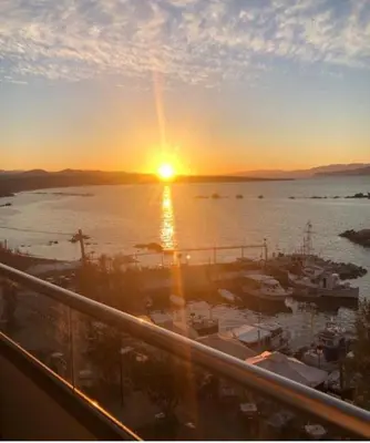 a sunset over a marina with boats in the water at stelisia2 in Chania Town