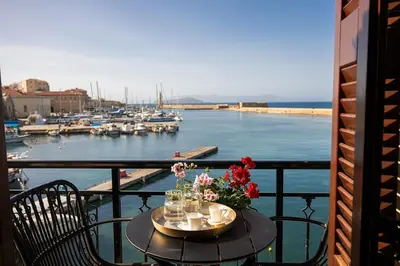 a table with flowers on a balcony with a marina at 3 Sails - 2BR on Venetian Harbour with Balcony in Chania Town