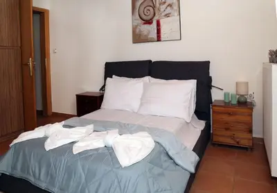 a bedroom with a large bed with towels on it at Komvos Apartment in Souda