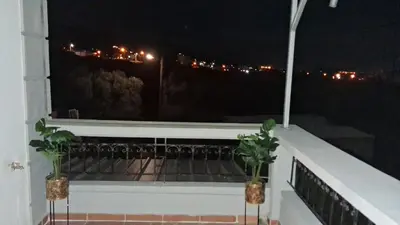 a balcony with two potted plants on it at night at Komvos Apartment in Souda