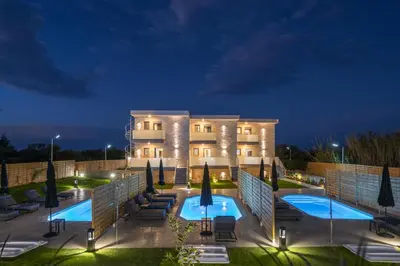 a hotel with a swimming pool at night at Armdin Seaview Villa 1 in Módhion