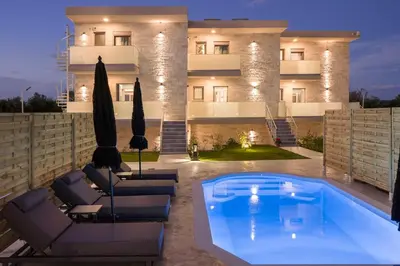 a villa with a swimming pool in front of a building at Armdin Seaview Villa 2 in Módhion