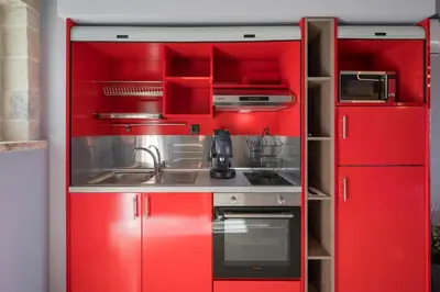 a red kitchen with red cabinets and a sink at Armdin Seaview Villa 2 in Módhion