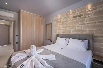 a bedroom with a large bed with a stone wall at Armdin Seaview Villa 3 in Módhion
