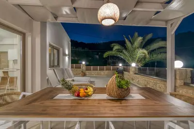a table with a bowl of fruit on a patio at Victoria Luxury Residence in Kissamos
