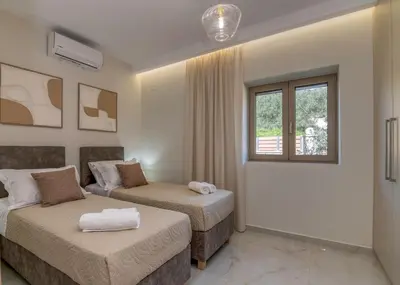 a hotel room with two beds and a window at Victoria Luxury Residence in Kissamos