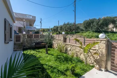 a backyard with a retaining wall and a fence at Victoria Luxury Residence in Kissamos