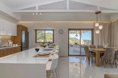 a kitchen and dining room with a table and chairs at Victoria Luxury Residence in Kissamos