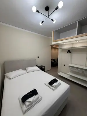 a bedroom with a large white bed with two phones on it at NESTIVA - Apartment in the Center of Chania in Chania Town