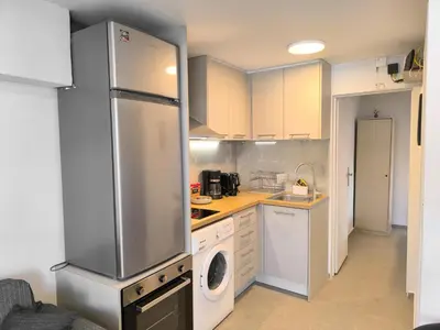 a kitchen with a refrigerator and a washing machine at Cozy Apartment with Private Jacuzzi - Fiber Internet - Private Parking in Chania Town