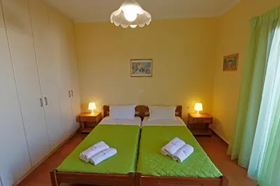 a bedroom with a green bed with towels on it at Glaros Home in Kato Daratso
