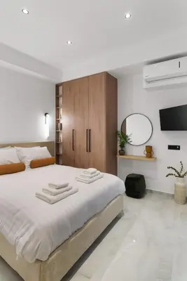 a bedroom with a large white bed and a tv at Elan Stay in Chania Town