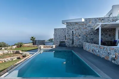 a swimming pool in front of a stone house at Aloni Villa with pool Kefalas in Vamos