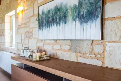 a painting hanging on a brick wall in a room at Villa Chara Chania in Agia Marina Nea Kydonias
