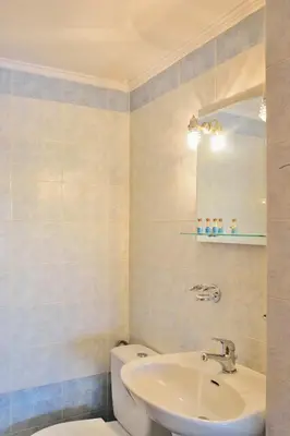 a bathroom with a sink and a toilet and a mirror at Sofoklis Apts in Stalos
