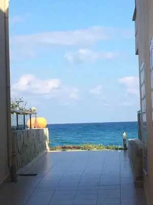 a view of the ocean from the balcony of a building at Kalyves Sand- Beach front apartment in Kalyves
