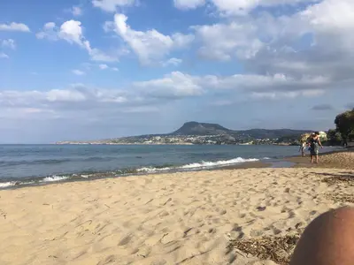 a group of people walking on the beach at Kalyves Sand- Beach front apartment in Kalyves