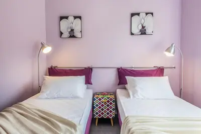 two beds in a room with purple walls at Villa Casa di Verde in Patellárion