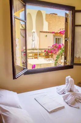 a bedroom with a window looking out at a courtyard at Iason Studios in Chania Town