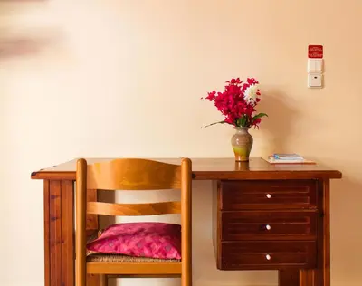 a wooden desk with a vase of flowers on it at Iason Studios in Chania Town