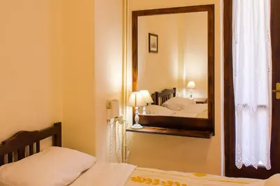 a mirror in a bedroom with two beds and a lamp at Iason Studios in Chania Town