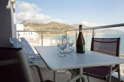 a table with two glasses and a bottle of wine at Paleochora Apartments in Palaiochóra