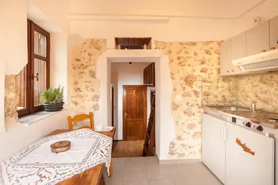 a small kitchen with a table and a sink at Hamam Suites Sifaka in Chania Town
