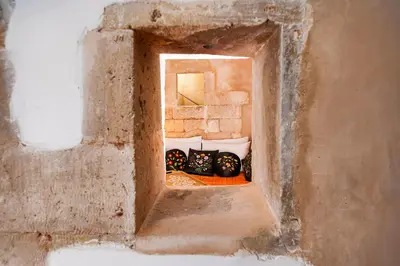 a hole in a wall in a building with pillows at Hamam Suites Sifaka in Chania Town