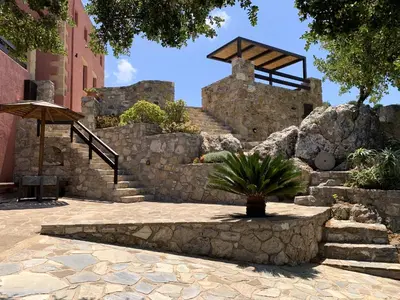 a stone staircase with a potted plant and an umbrella at Archon Villa in Pandeleḯmon